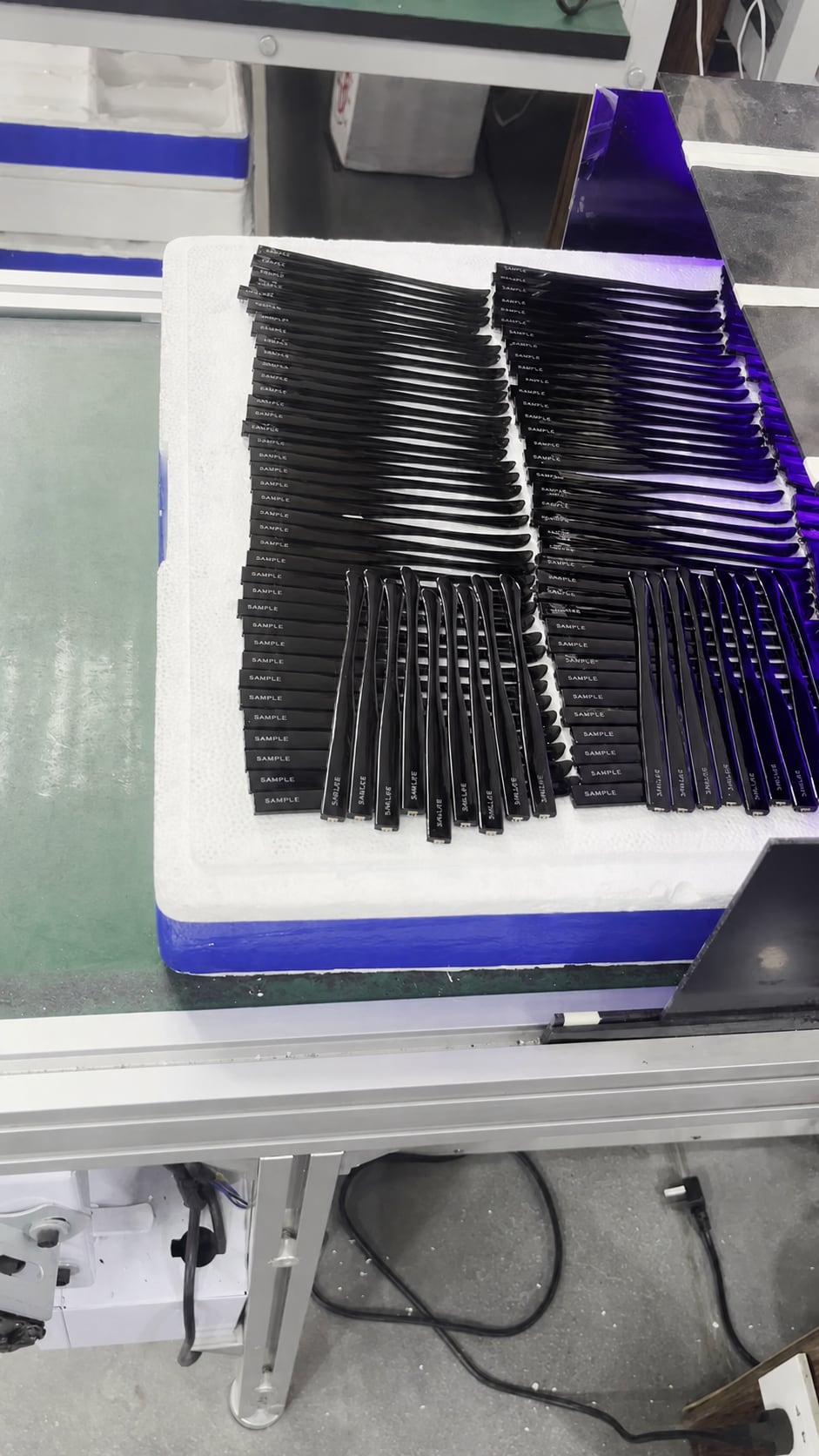 Printed eyewear temples arranged for drying before foil transfer